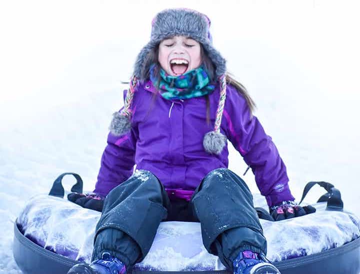 Girl laughing on snow tube at Bousquet Mountain