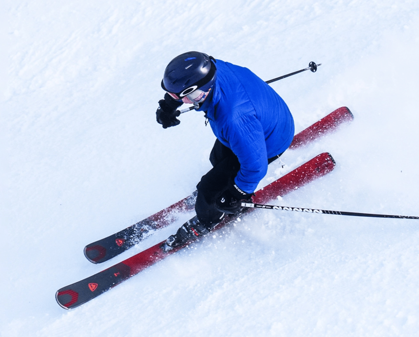 Skier in blue jacket heading down slopes on fresh powder at Bousquet Mountain
