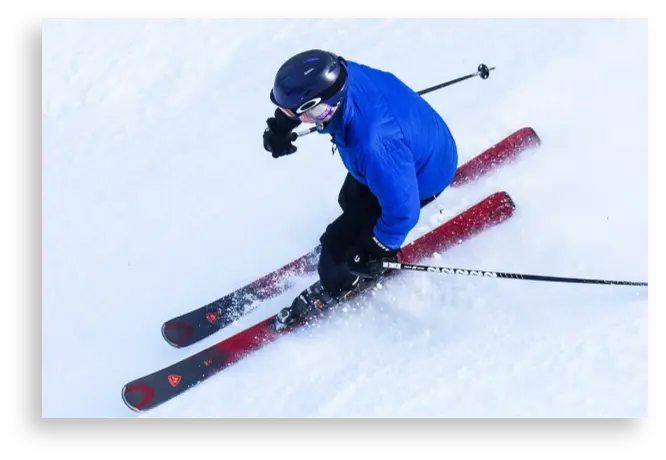 Skier in blue jacket heading down slopes on fresh powder at Bousquet Mountain