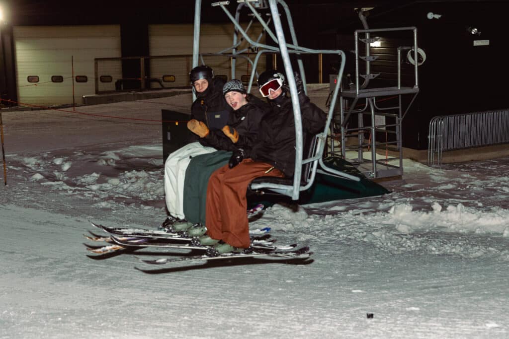 Skiiers on a chairlift for Night Skiing at Bousquet Mountain