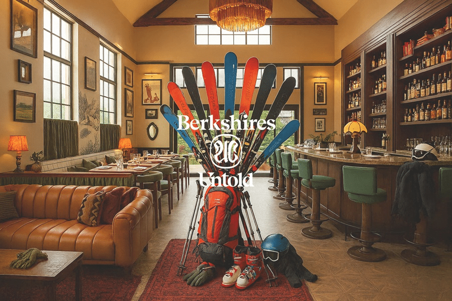 Berkshires Untold logo overlays an image of skis and a backpack with ski gear, sitting in the lobby of the hotel in Lenox Massachusetts.